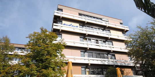 Ein mehrstöckiges Gebäude umgeben von Bäumen.
